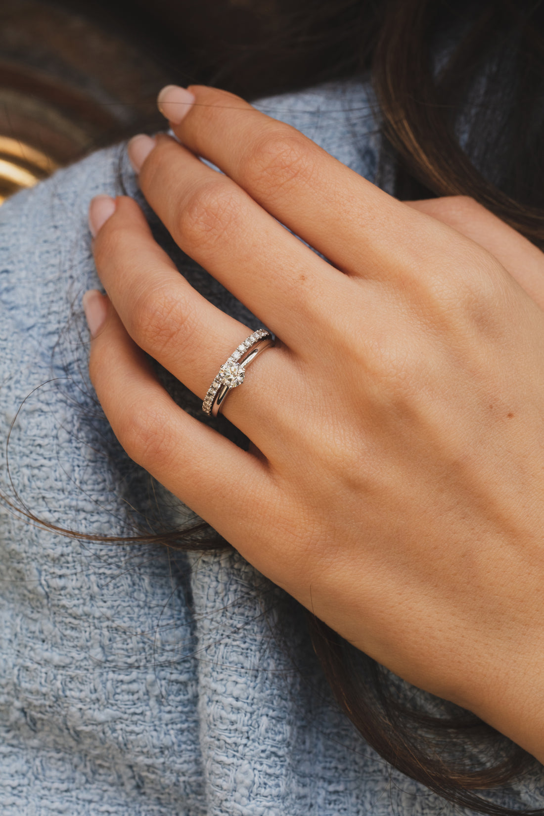 Main de femme portant un duo de bagues de mariage en or et diamants