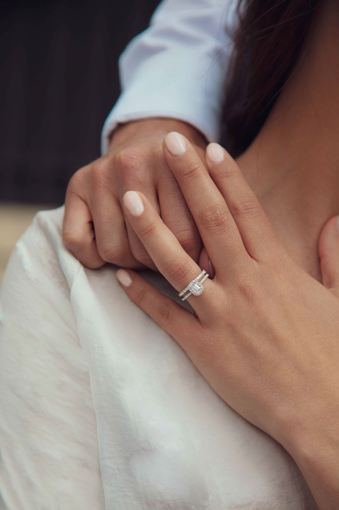 Couple se tenant la main. La femme porte un duo de diamants