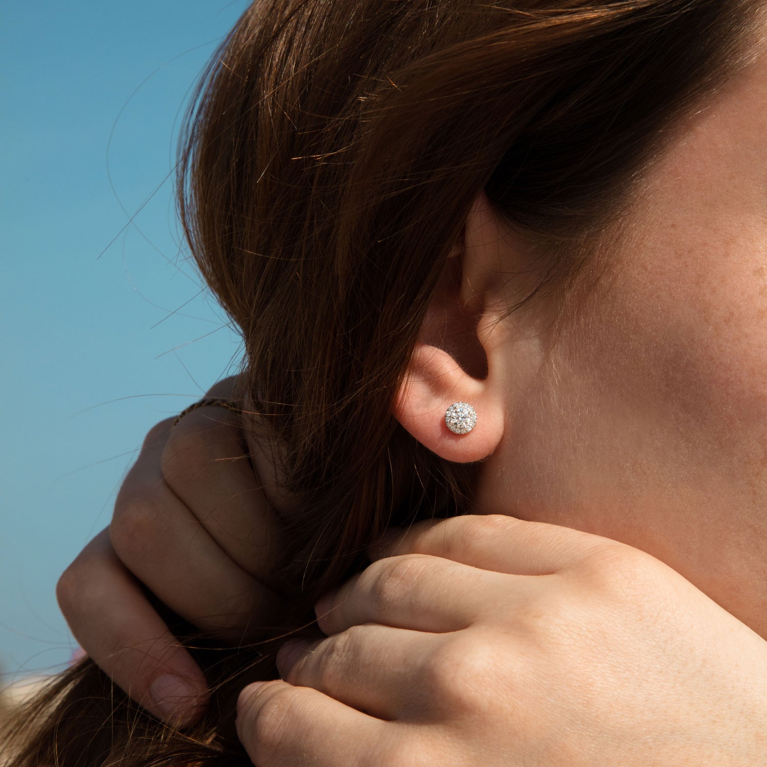 Femme portant des boucles d'oreilles en diamants certifiés