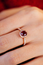 Photo en plan rapproché de la bague Camélia accompagné et halo, en rubis et or rose 18 carats