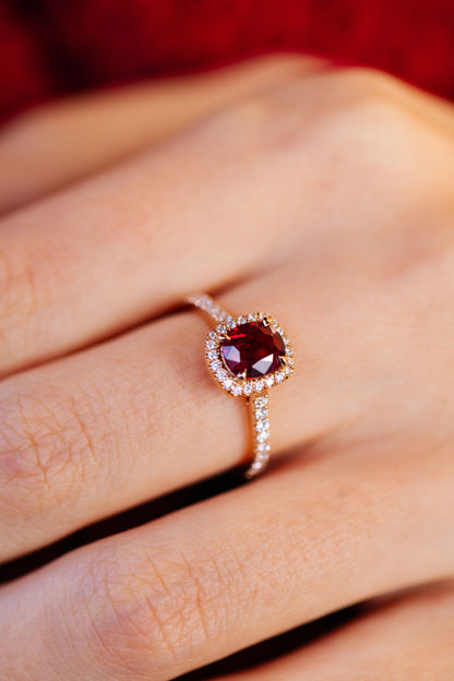 Photo en plan rapproché de la bague Camélia accompagné et halo, en rubis et or rose 18 carats