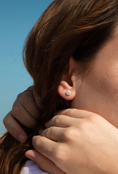 Photo porté des boucles d'oreilles en diamants naturels et or blanc, modèle Orion, forme rond avec halo