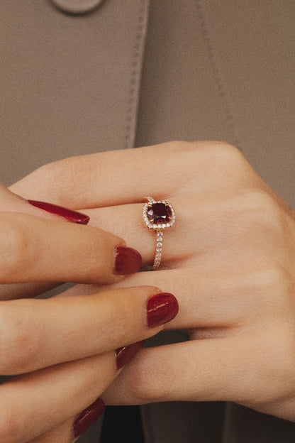 Photo porté de la bague en rubis. La bague contraste avec le look sobre de la femme.