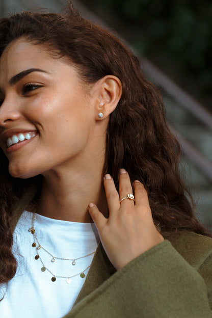 Photo porté des boucles d'oreilles en diamants naturels et or jaune, modèle Orion, forme rond avec halo